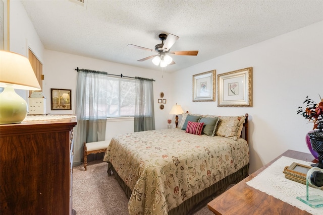 carpeted bedroom featuring ceiling fan and a textured ceiling