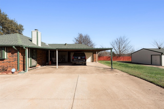 view of side of property featuring a carport, a yard, and a storage unit