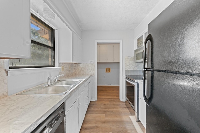 kitchen with sink, white cabinetry, a textured ceiling, light hardwood / wood-style floors, and black appliances