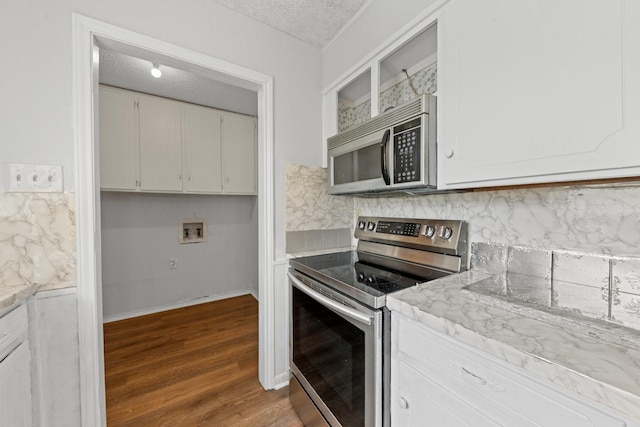 kitchen featuring white cabinetry, dark wood-type flooring, stainless steel appliances, and a textured ceiling