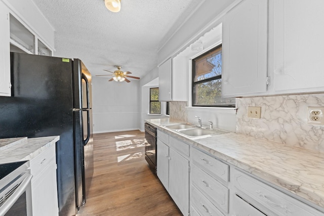 kitchen featuring tasteful backsplash, white cabinetry, sink, and black appliances