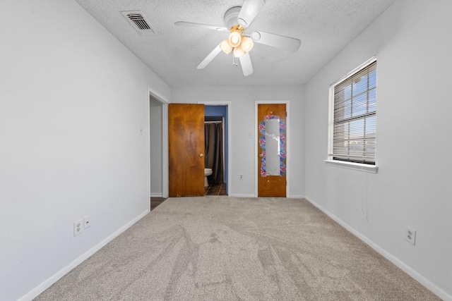 empty room featuring ceiling fan, carpet floors, and a textured ceiling