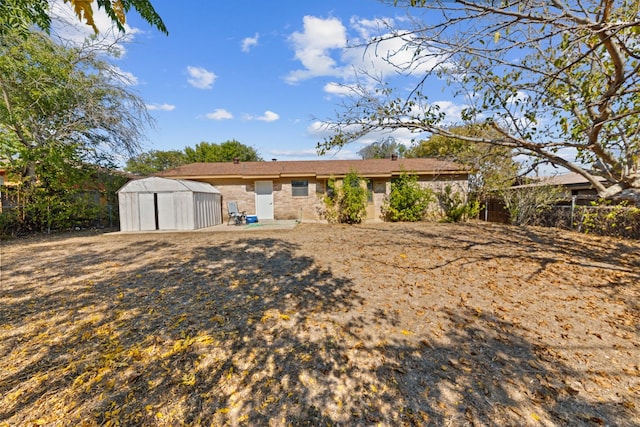 back of property with a patio area and a shed