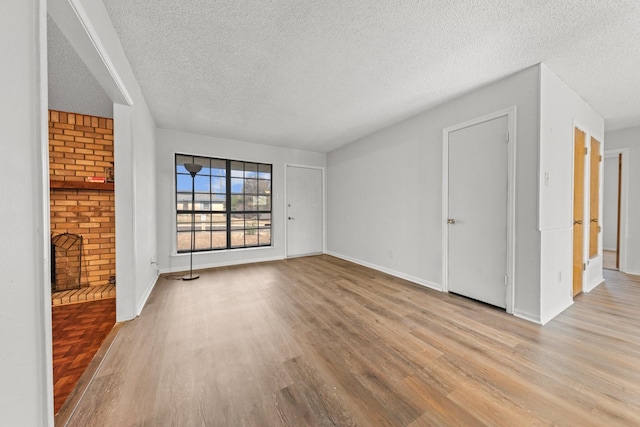 unfurnished living room featuring a textured ceiling and light wood-type flooring