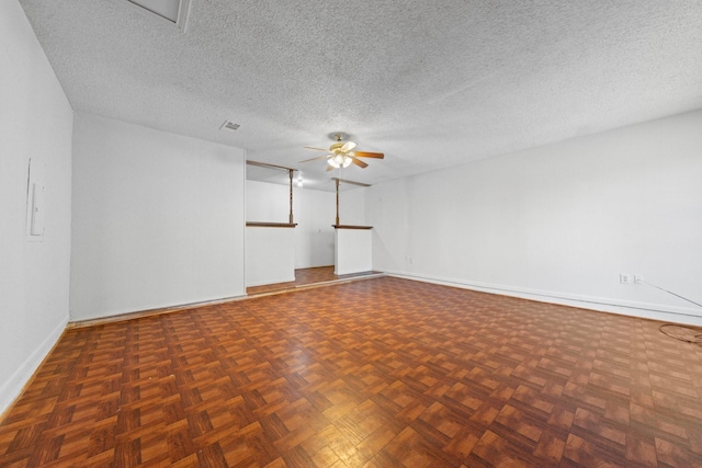 unfurnished room featuring a textured ceiling, dark parquet floors, and ceiling fan