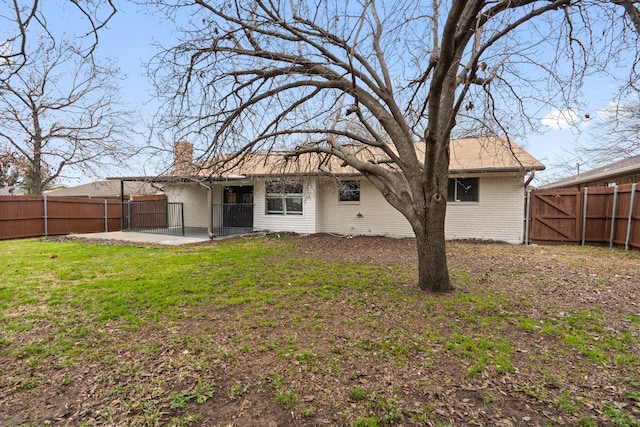 rear view of property featuring a patio and a lawn