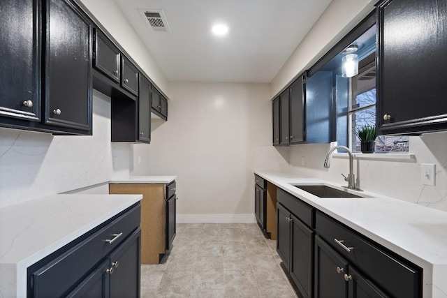 kitchen featuring light stone counters, sink, and backsplash