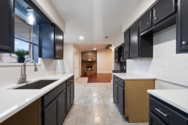 kitchen with tasteful backsplash, a fireplace, and sink