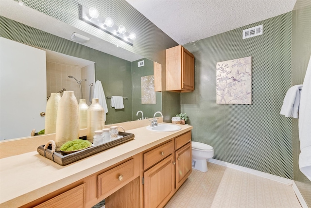 bathroom featuring vanity, a textured ceiling, toilet, and walk in shower