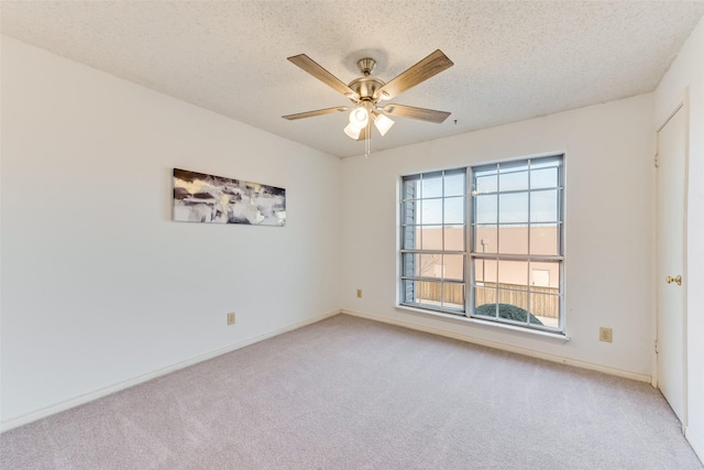 carpeted spare room featuring ceiling fan and a textured ceiling