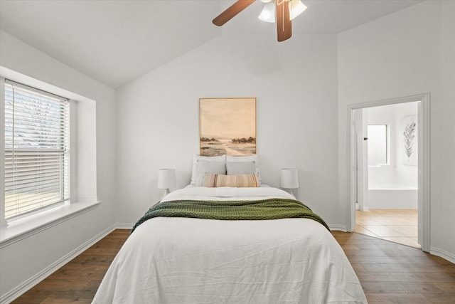 bedroom with lofted ceiling, hardwood / wood-style floors, connected bathroom, and ceiling fan