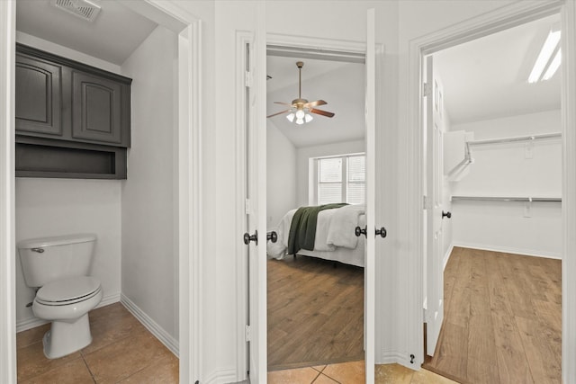 bathroom featuring tile patterned floors, toilet, and vaulted ceiling