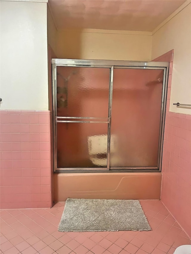 bathroom featuring bath / shower combo with glass door, tile walls, and tile patterned floors