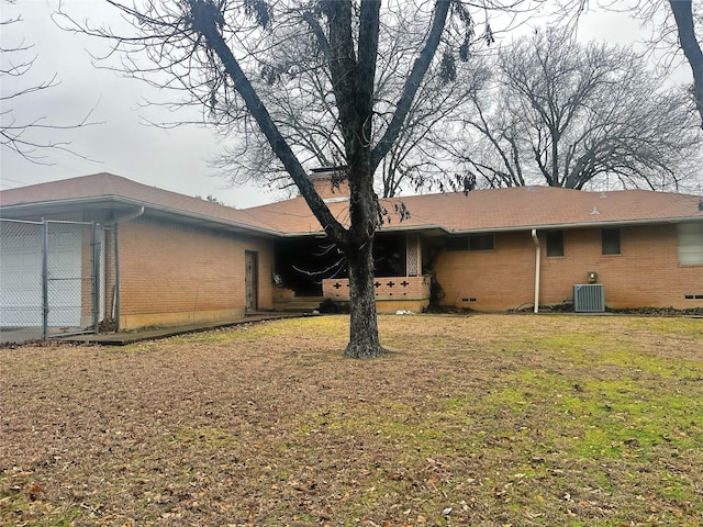 back of property with cooling unit and a lawn