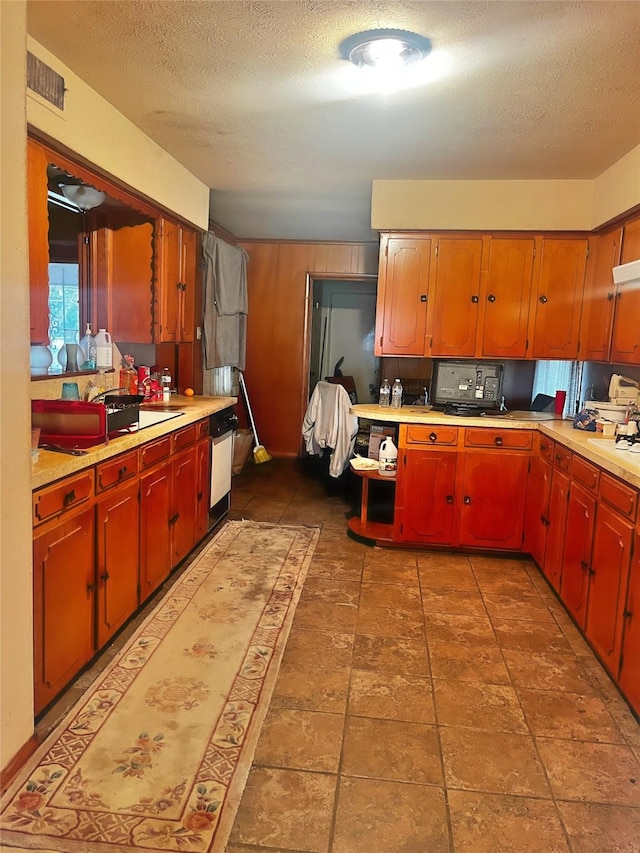 kitchen featuring stainless steel dishwasher and a textured ceiling