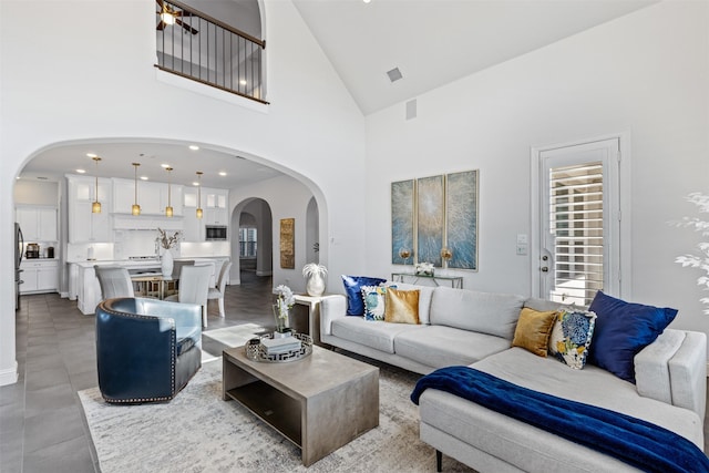 living room with a towering ceiling and light tile patterned floors