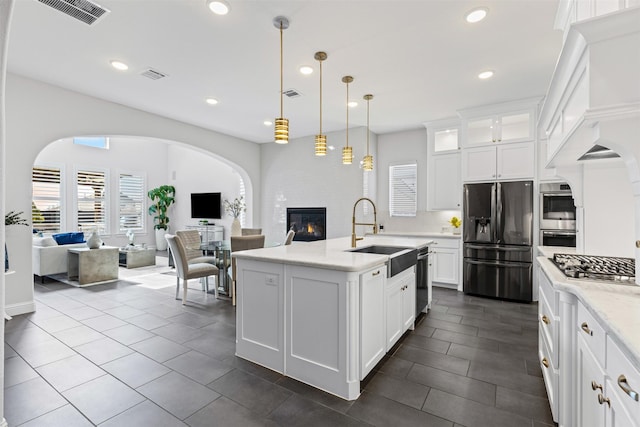 kitchen with white cabinetry, stainless steel appliances, sink, and pendant lighting