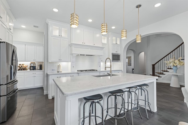 kitchen with white cabinetry, sink, decorative light fixtures, and appliances with stainless steel finishes