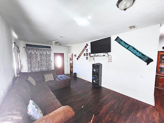 living room featuring dark wood-type flooring and ceiling fan