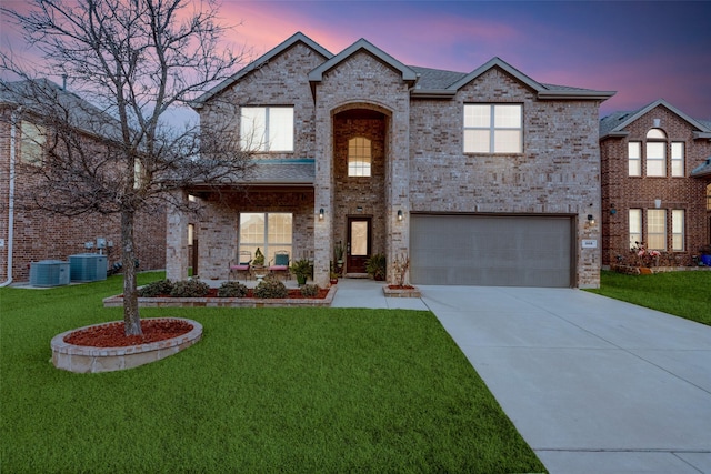 view of front facade featuring a garage, central AC unit, and a lawn