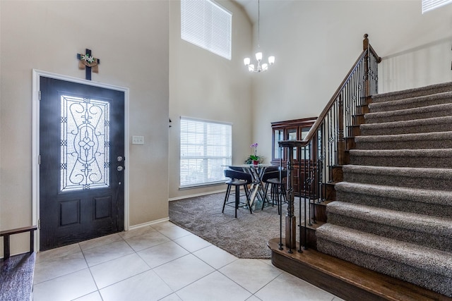 foyer entrance with an inviting chandelier, light tile patterned floors, and a towering ceiling