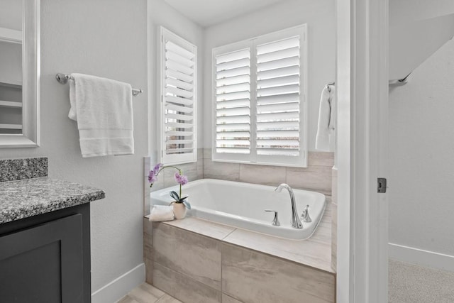 bathroom featuring vanity and a relaxing tiled tub