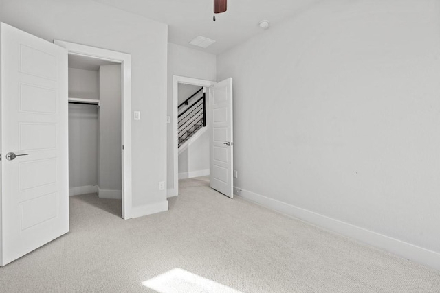 unfurnished bedroom featuring ceiling fan, light colored carpet, and a closet