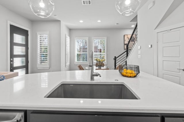 kitchen with light stone counters, stainless steel dishwasher, and sink