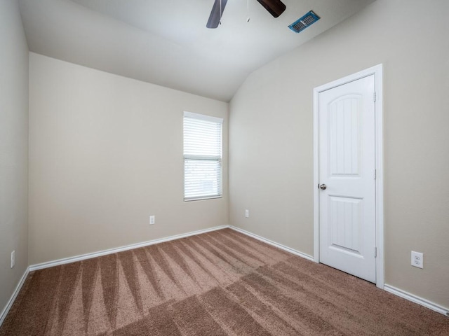 spare room featuring lofted ceiling, ceiling fan, and carpet