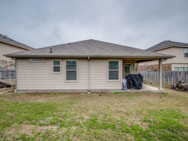 rear view of property featuring a patio and a lawn