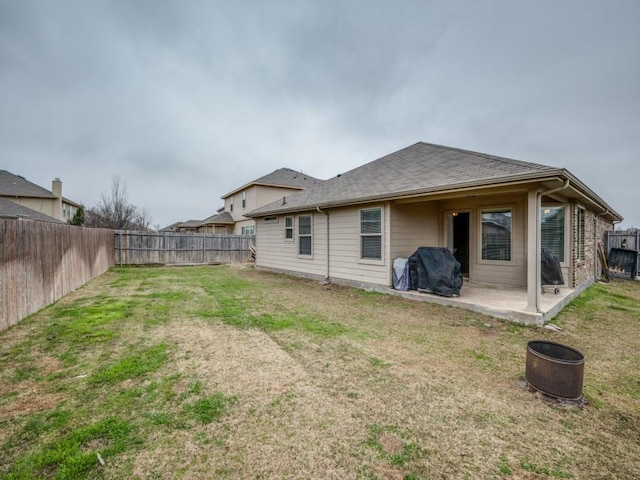 rear view of property featuring a yard and a patio