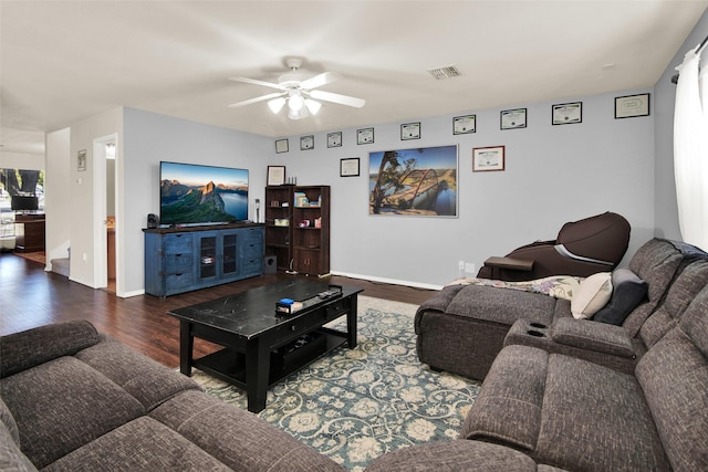 living room featuring dark wood-type flooring and ceiling fan