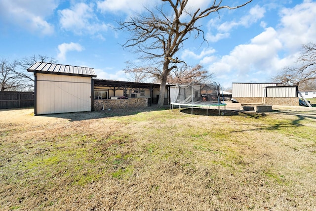 view of yard featuring a trampoline and a storage shed