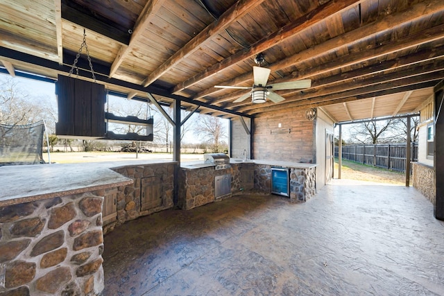 view of patio / terrace featuring area for grilling, ceiling fan, and exterior kitchen