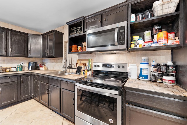 kitchen featuring decorative backsplash, appliances with stainless steel finishes, sink, and dark brown cabinets