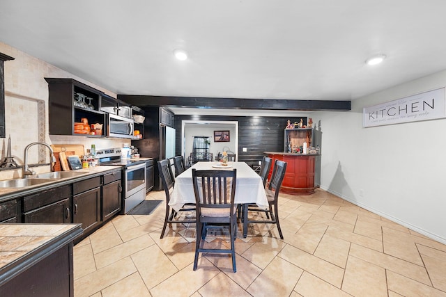 kitchen with sink, stainless steel appliances, and light tile patterned flooring