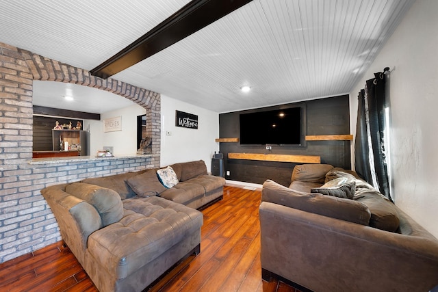 living room featuring hardwood / wood-style flooring and brick wall