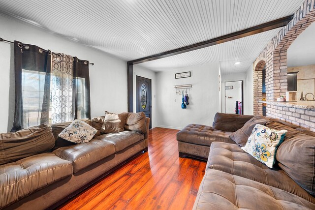 living room with beam ceiling and wood-type flooring