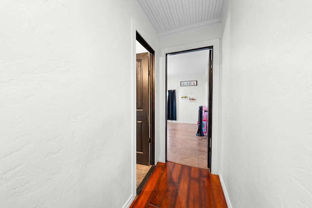 hallway with hardwood / wood-style flooring and ornamental molding