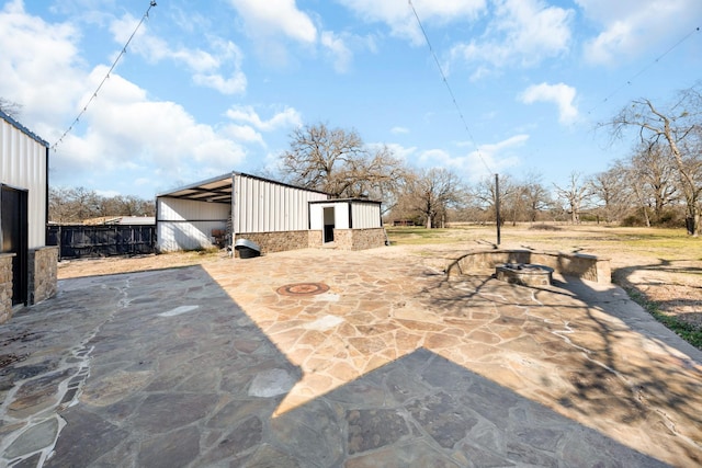 view of patio / terrace with an outdoor structure and an outdoor fire pit