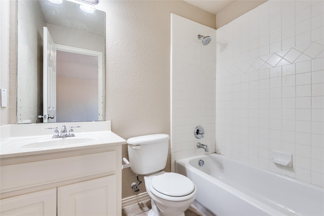 full bathroom featuring tiled shower / bath combo, vanity, and toilet