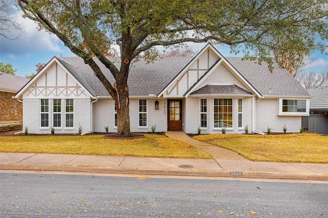 english style home with a front lawn