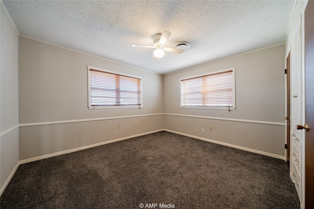 empty room featuring crown molding, ceiling fan, a textured ceiling, and dark colored carpet