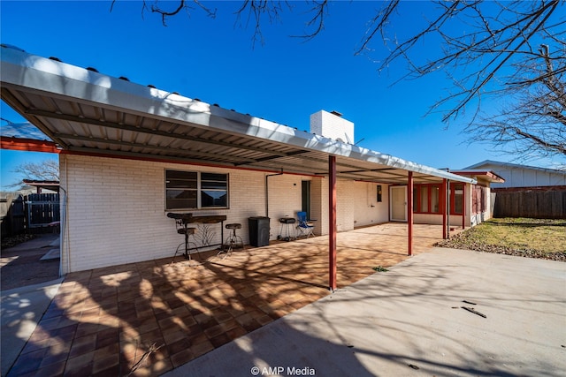 rear view of house featuring a carport and a patio area