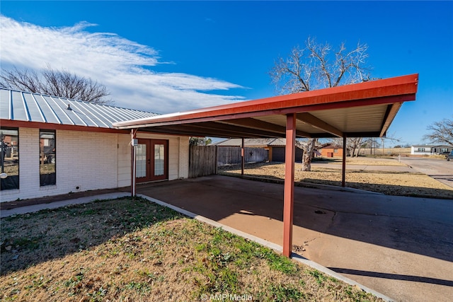 view of parking featuring a carport and french doors