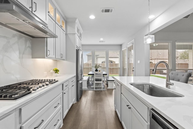 kitchen featuring sink, white cabinetry, hanging light fixtures, appliances with stainless steel finishes, and dark hardwood / wood-style floors