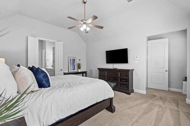 bedroom featuring light carpet, vaulted ceiling, ceiling fan, and ensuite bathroom