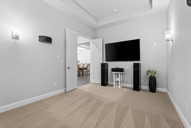 unfurnished living room featuring a raised ceiling and carpet floors