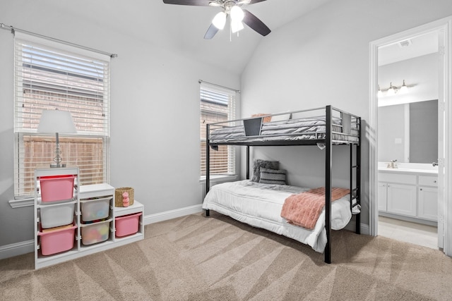 carpeted bedroom with connected bathroom, vaulted ceiling, and ceiling fan