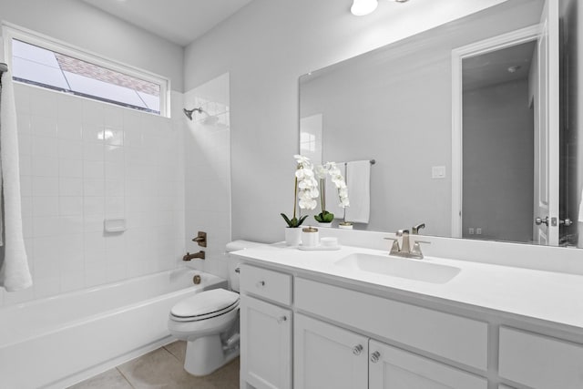 full bathroom featuring tiled shower / bath, vanity, tile patterned floors, and toilet